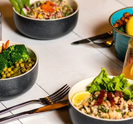 A vibrant assortment of healthy bowls and drinks showcasing fresh ingredients like broccoli and citrus.