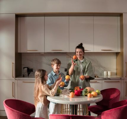 Mother with children preparing meals with fresh ingredients in a modern kitchen.