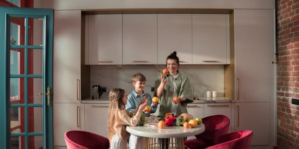 Mother with children preparing meals with fresh ingredients in a modern kitchen.